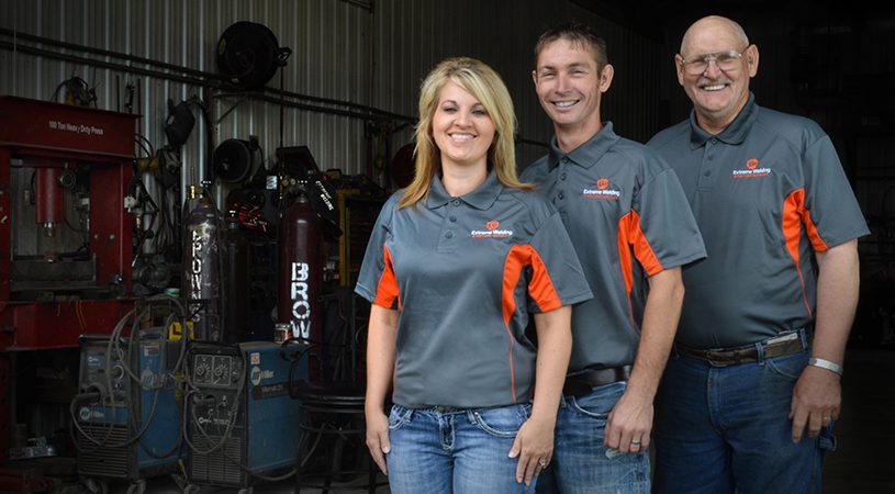 Three people standing in front of a fire truck.